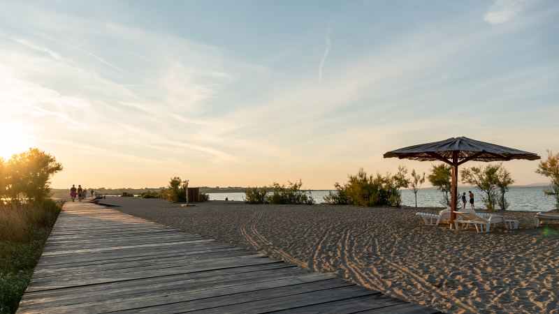 Sandstrand mit Holzsteg und Strohschirm bei Sonnenuntergang – Villa DEA in Vrsi-Mulo bei Zadar