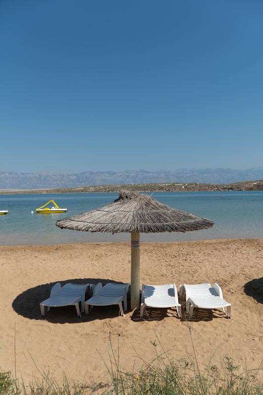 Sandstrand mit Strohschirm, Liegen und Blick auf das Velebit-Gebirge – Villa DEA in Vrsi-Mulo bei Zadar