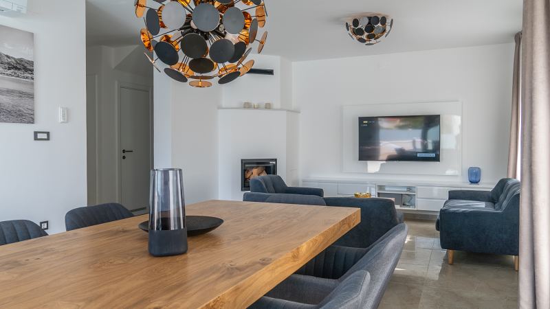 Blick vom Esstisch ins Wohnzimmer mit Kamin und TV – Villa DEA in Vrsi-Mulo bei Zadar