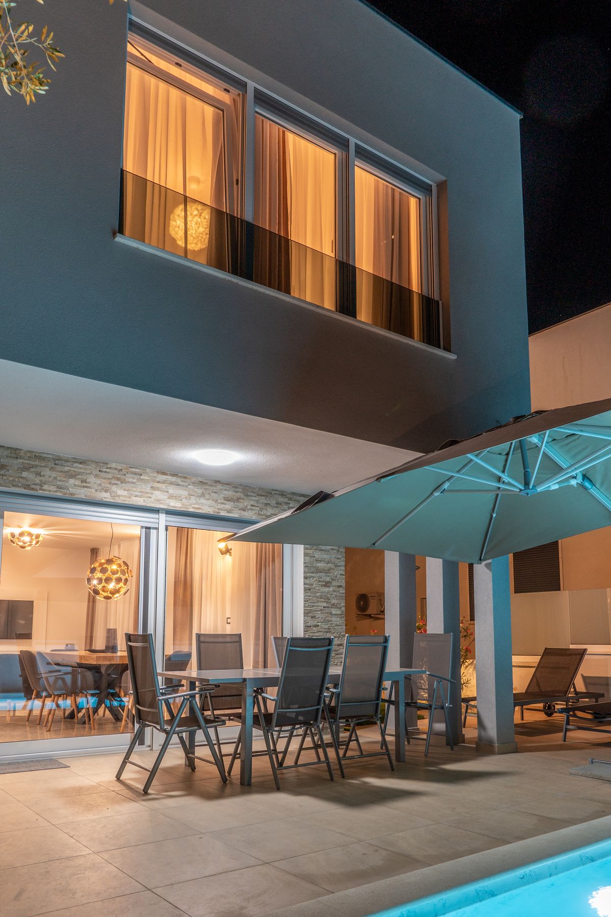 Ferienhaus Villa DEA am Abend mit Terrasse, Esstisch und beleuchtetem Pool in Vrsi-Mulo