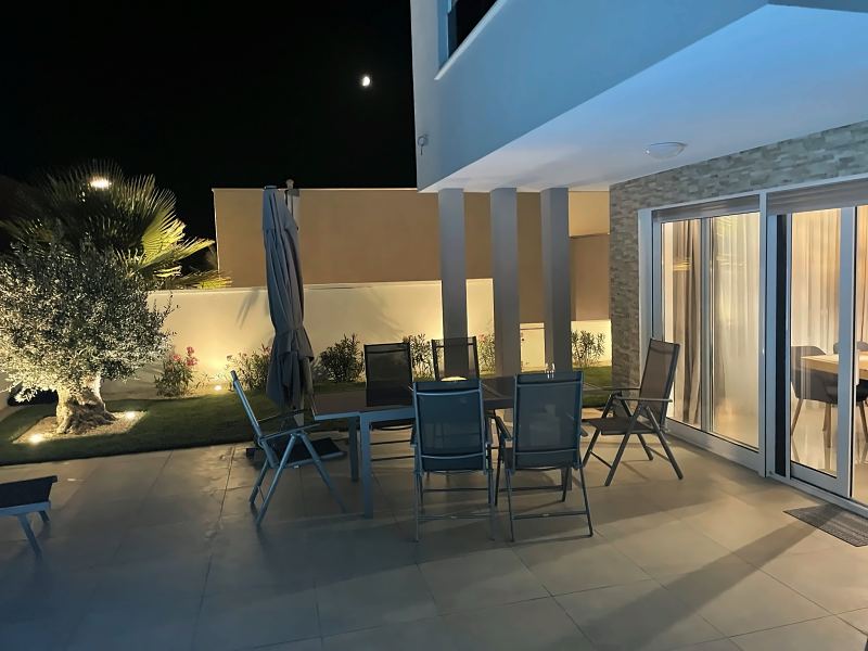 Terrasse mit Esstisch und beleuchtetem Olivenbaum am Abend – Villa DEA in Vrsi-Mulo bei Zadar
