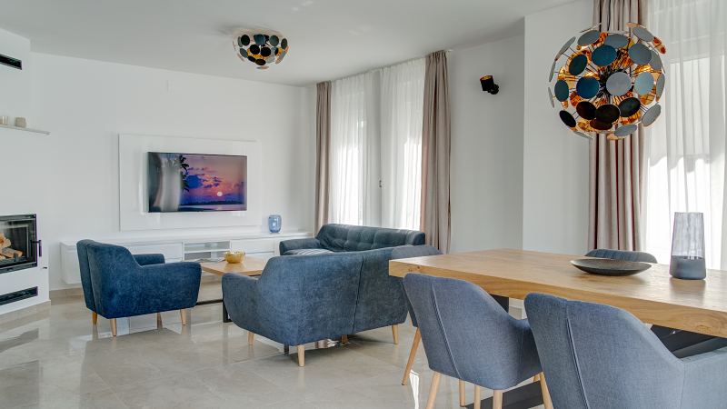 Wohn- und Essbereich mit blauen Sofas und Kamin – Villa DEA in Vrsi-Mulo bei Zadar